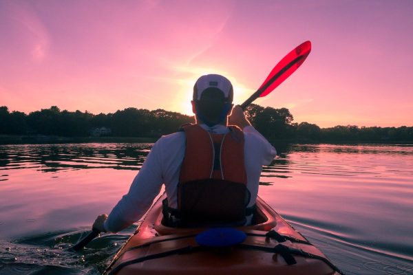Kayaker paddles during sunset